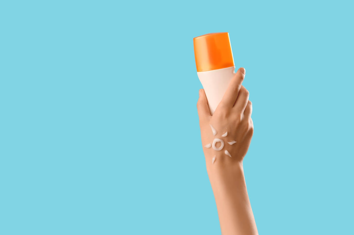 Ręka ze słońcem narysowanym z kremu trzyma SPF.