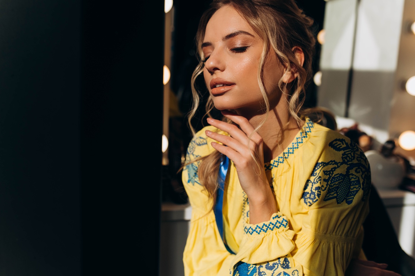 Kobieta w makijażu soft glam z rozświetloną cerą, delikatnym makijażem oczu i nude ustami.