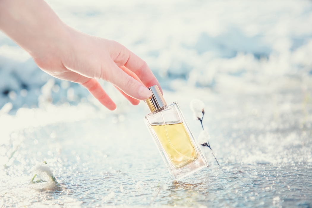 Flakon perfum stoi na zamarzniętej ziemi
