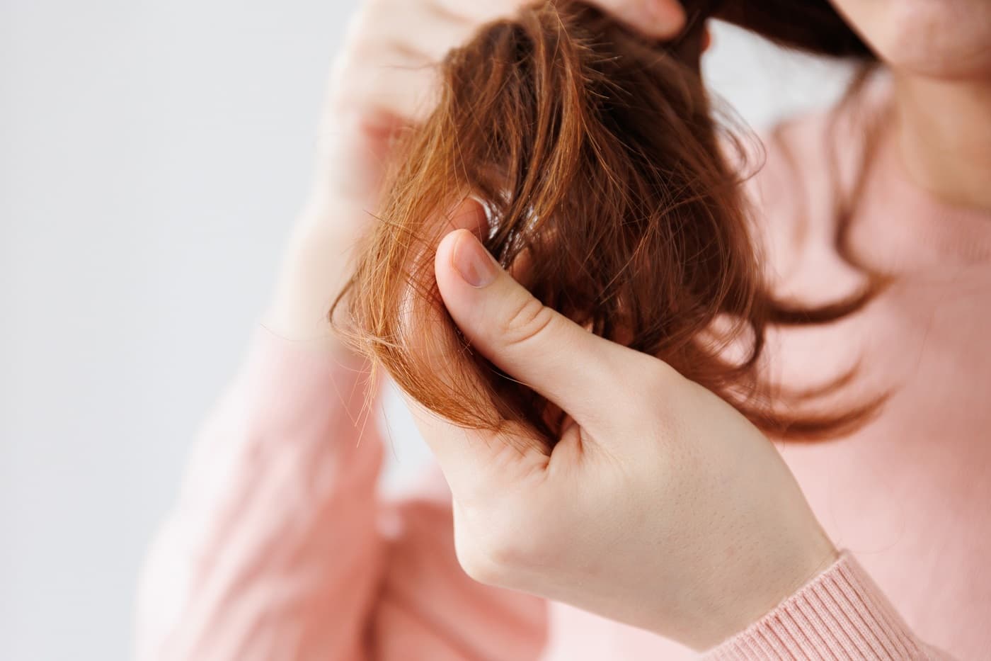 Kobieta próbuje rozczesać zniszczone włosy