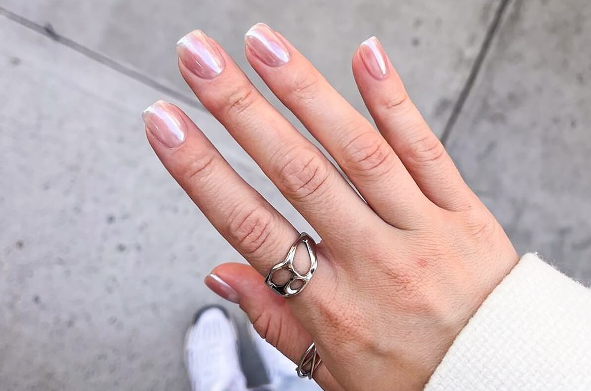 Kobieca dłoń z delikatnym manicure w stylu chrome nails