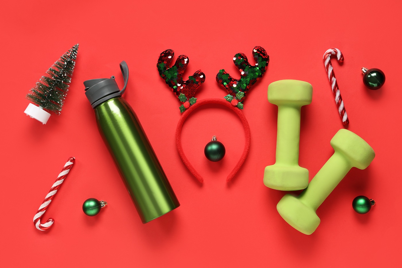 Świąteczne akcesoria sportowe - zielony bidon, hantle, świąteczna opaska z rogami renifera oraz dekoracje
