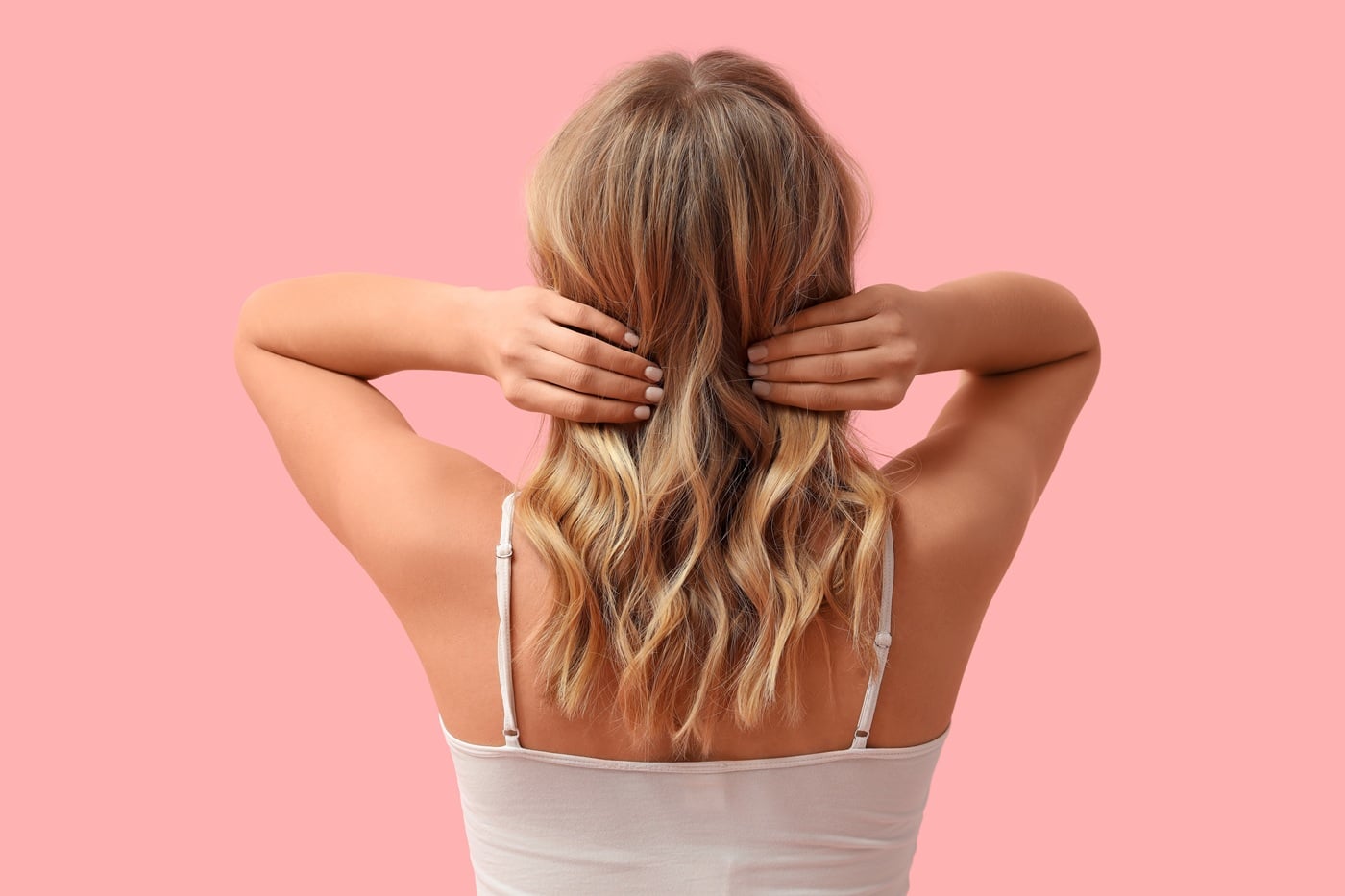 Kobieta pokazana od tyłu, z falowanymi włosami w naturalnych, ciepłych tonach blondu i brązu.
