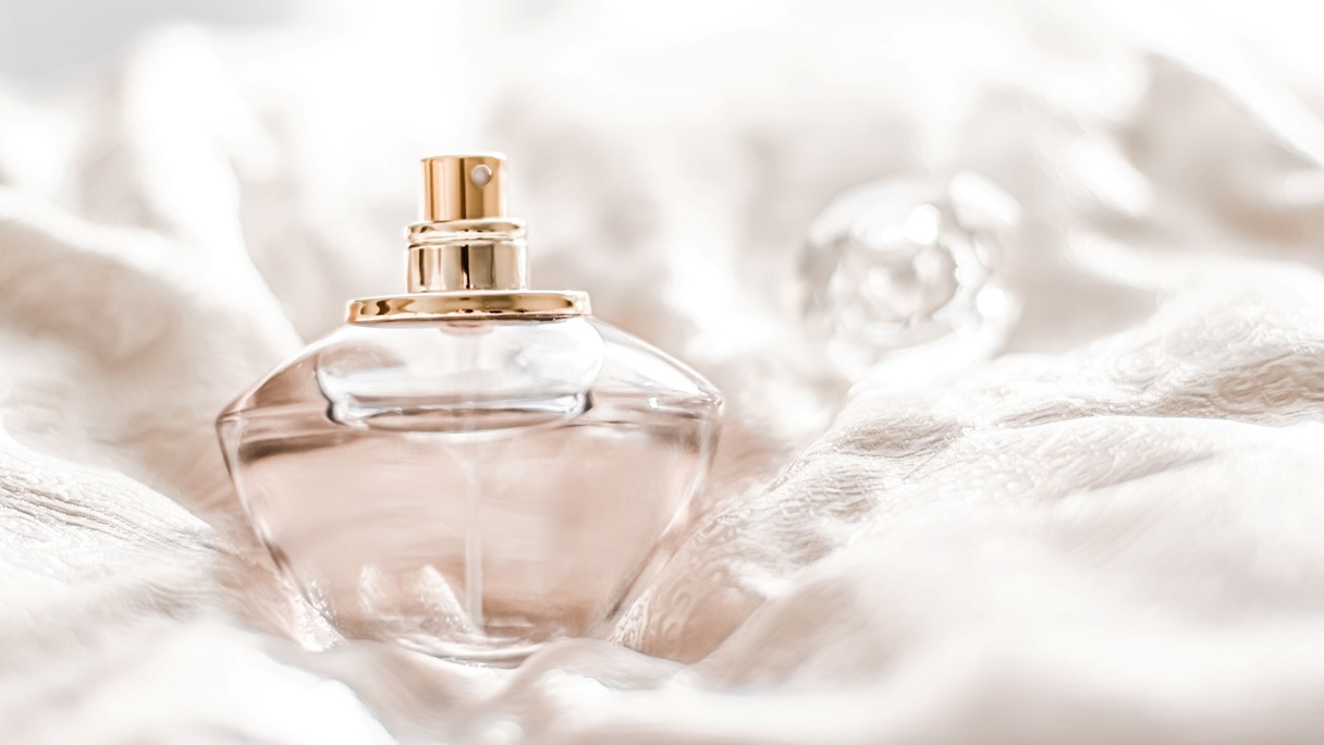 Flakon perfum na jasnej, miękkiej tkaninie