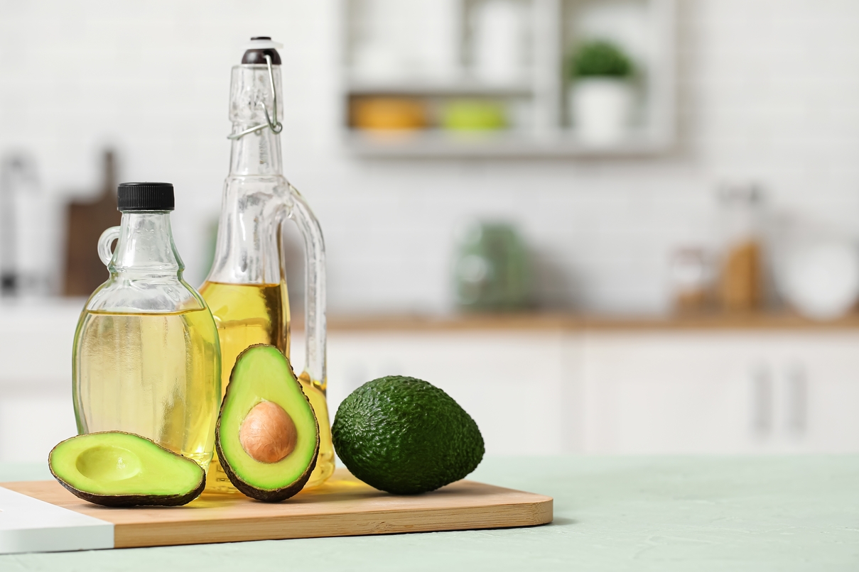 Butelka z oleju z awokado i świeży owoc awokado