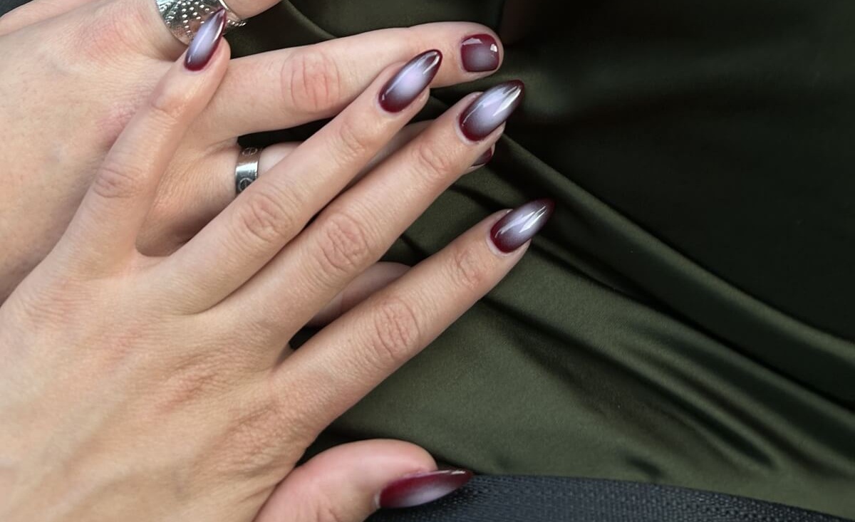Dłonie z manicure wykonanym w stylu aura nails